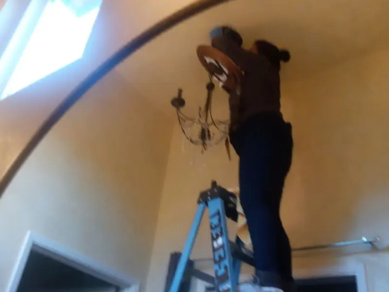Electrician installing a chandelier in a Niagara residence